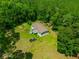 Aerial view of home showcasing wrap around porch, nestled in lush wooded landscape at 21375 Nw 150Th Avenue Rd, Micanopy, FL 32667