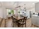 Open-concept kitchen with a wooden table and pendant lighting, white cabinetry and island, and modern appliances at 21375 Nw 150Th Avenue Rd, Micanopy, FL 32667