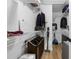 Functional laundry room with storage shelves, hanging racks, and hardwood-style floors at 21375 Nw 150Th Avenue Rd, Micanopy, FL 32667
