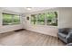 Cozy living room featuring light wood floors, neutral walls, and a large window with backyard views at 21375 Nw 150Th Avenue Rd, Micanopy, FL 32667