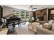 Cozy living room features a stone fireplace, a piano, and ample natural light from large windows at 21375 Nw 150Th Avenue Rd, Micanopy, FL 32667