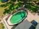 Aerial view of a private fenced in backyard pool with brick pavers, patio furniture, and lush landscaping at 21375 Nw 150Th Avenue Rd, Micanopy, FL 32667