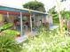 Expansive backyard featuring a covered patio, lush lawn, and vibrant tropical foliage at 39 Benjamin Dr, Ormond Beach, FL 32176