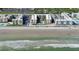 Aerial of a condo complex on a beach with parking and a central pool at 4155 S Atlantic Ave # 204, New Smyrna Beach, FL 32169