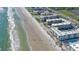 An aerial view shows a beachfront condominium complex next to a sandy beach and the Atlantic Ocean at 4155 S Atlantic Ave # 204, New Smyrna Beach, FL 32169