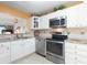 Bright kitchen features white cabinets, stainless steel appliances, granite countertops, and a pass-through to the living area at 89 S Atlantic Ave # 1004, Ormond Beach, FL 32176