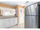 Kitchen featuring white cabinets, granite counters, stainless appliances and a pass-through to the living area with a stainless refrigerator at 89 S Atlantic Ave # 1004, Ormond Beach, FL 32176