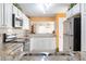 Bright kitchen features white cabinets, granite countertops, stainless steel appliances, and a pass-through to the living area at 89 S Atlantic Ave # 1004, Ormond Beach, FL 32176