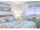 Serene main bedroom showcasing a detailed quilt, a bright window with ocean views, and a coastal aesthetic at 89 S Atlantic Ave # 1004, Ormond Beach, FL 32176