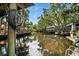 Waterfront view showcasing dock extending onto the waterway, surrounded by lush trees and clear blue sky at 1108 Shockney Dr, Ormond Beach, FL 32174