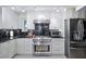 Modern kitchen with stainless steel appliances, custom white cabinetry, and black marble countertops at 1108 Shockney Dr, Ormond Beach, FL 32174