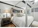 Main bedroom featuring hardwood floors, a four-poster bed, and decorative bedside lighting at 1108 Shockney Dr, Ormond Beach, FL 32174