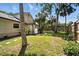 Spacious grassy yard featuring a propane tank and stepping stones leading to a wooden fence at 1108 Shockney Dr, Ormond Beach, FL 32174