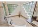 Corner bathtub features tile surround with a glass block window at 1254 Royal Pointe Ln, Ormond Beach, FL 32174