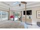 Bright bedroom features a tray ceiling, ceiling fan, television, and sliding glass doors to the pool area at 1254 Royal Pointe Ln, Ormond Beach, FL 32174