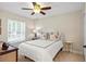 Cozy bedroom featuring neutral walls, ceiling fan, natural light, and comfortable furnishings at 1254 Royal Pointe Ln, Ormond Beach, FL 32174