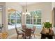 Cozy breakfast nook with views of the pool, featuring a glass table and modern chandelier at 1254 Royal Pointe Ln, Ormond Beach, FL 32174