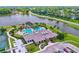 Aerial view of the Plantation Bay clubhouse, featuring a resort-style pool, lush landscaping and parking at 1254 Royal Pointe Ln, Ormond Beach, FL 32174