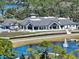 Beautiful clubhouse view with manicured lawns, a lake with a fountain, and golf carts lined up ready for a day on the course at 1254 Royal Pointe Ln, Ormond Beach, FL 32174