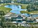 Stunning aerial view of clubhouse overlooking lake, and golf course, with ample parking for members and guests at 1254 Royal Pointe Ln, Ormond Beach, FL 32174