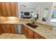 Open kitchen with granite countertops, stainless steel appliances, and a view into the living area at 1254 Royal Pointe Ln, Ormond Beach, FL 32174