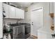 Well-equipped laundry room with modern washer and dryer, along with ample white cabinet storage at 1254 Royal Pointe Ln, Ormond Beach, FL 32174