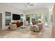 Bright living room with ceiling fan, neutral furniture, and sliding glass doors to the pool at 1254 Royal Pointe Ln, Ormond Beach, FL 32174