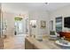 Open-concept living room with neutral tones, tile floors, and an elegant front door entrance at 1254 Royal Pointe Ln, Ormond Beach, FL 32174
