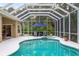 Beautifully maintained screened-in pool area with a spa and a lush, tropical backdrop at 1254 Royal Pointe Ln, Ormond Beach, FL 32174