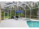 Secluded screened-in pool area with a spa, sun loungers, umbrella, and a lush backdrop at 1254 Royal Pointe Ln, Ormond Beach, FL 32174