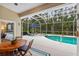 Secluded screened-in pool area with a spa, sun loungers, umbrella, and mature trees at 1254 Royal Pointe Ln, Ormond Beach, FL 32174