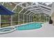 Screened pool area with a spa, sun loungers, umbrella and a lush green backdrop at 1254 Royal Pointe Ln, Ormond Beach, FL 32174