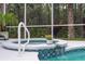 Close up on the pool's spa, with beautiful tiling, a small waterfall and handrail for access at 1254 Royal Pointe Ln, Ormond Beach, FL 32174