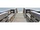Wooden boardwalk leading to a beach with an umbrella in the background at 146 Via Madrid Dr, Ormond Beach, FL 32176