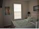 Bedroom featuring a comfy bed with a mirror and a decorative painting above at 146 Via Madrid Dr, Ormond Beach, FL 32176