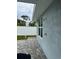 Outdoor shower on the side of a blue home with brick pavers and a white fence at 146 Via Madrid Dr, Ormond Beach, FL 32176