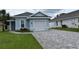 Charming home showcasing a neatly paved driveway and a well-maintained, inviting lawn area at 146 Via Madrid Dr, Ormond Beach, FL 32176