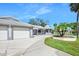 A long driveway and two-car garage with lush landscaping create an inviting exterior at 1650 Riverside Dr, Daytona Beach, FL 32117