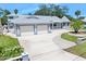 An exterior elevation showcases a home with a spacious driveway, two-car garage, lush landscaping, and inviting curb appeal at 1650 Riverside Dr, Daytona Beach, FL 32117