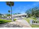 An exterior view presents a well-maintained home with lovely landscaping, mature trees, and a long driveway leading to a garage at 1650 Riverside Dr, Daytona Beach, FL 32117
