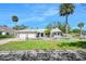 The front exterior view showcases an inviting house with a well-manicured lawn, mature trees, and a two-car garage at 1650 Riverside Dr, Daytona Beach, FL 32117