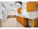 The kitchen features wood cabinetry, tile countertops and flooring, with a double basin sink at 1650 Riverside Dr, Daytona Beach, FL 32117