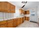 This kitchen features wood cabinetry, tile countertops, and a double basin stainless steel sink at 1650 Riverside Dr, Daytona Beach, FL 32117