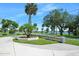 Quaint street view featuring lush tropical landscaping, concrete driveway, and distant waterfront access at 1650 Riverside Dr, Daytona Beach, FL 32117