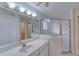 Bathroom with a wide mirror above a vanity with white drawers and a glass enclosed shower at 24 Katrinas Dr, Ormond Beach, FL 32174