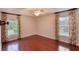 Bright bedroom featuring wood floors, ceiling fan, and windows with floral curtains for a cozy aesthetic at 24 Katrinas Dr, Ormond Beach, FL 32174
