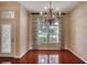 Bright dining room features a chandelier, a large window, and hardwood floors at 24 Katrinas Dr, Ormond Beach, FL 32174