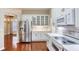 Bright kitchen features white cabinets, stainless steel appliances, with wood floors and view to dining room at 24 Katrinas Dr, Ormond Beach, FL 32174