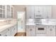 Kitchen with white cabinets and stainless steel appliances with view to laundry area at 24 Katrinas Dr, Ormond Beach, FL 32174