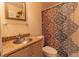 Cozy bathroom featuring a granite countertop, decorative shower curtain, and a decorative mirror at 3000 Ocean Shore Blvd # 18, Ormond Beach, FL 32176
